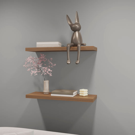 Polished metallic rabbit sculpture sitting on a wooden shelf