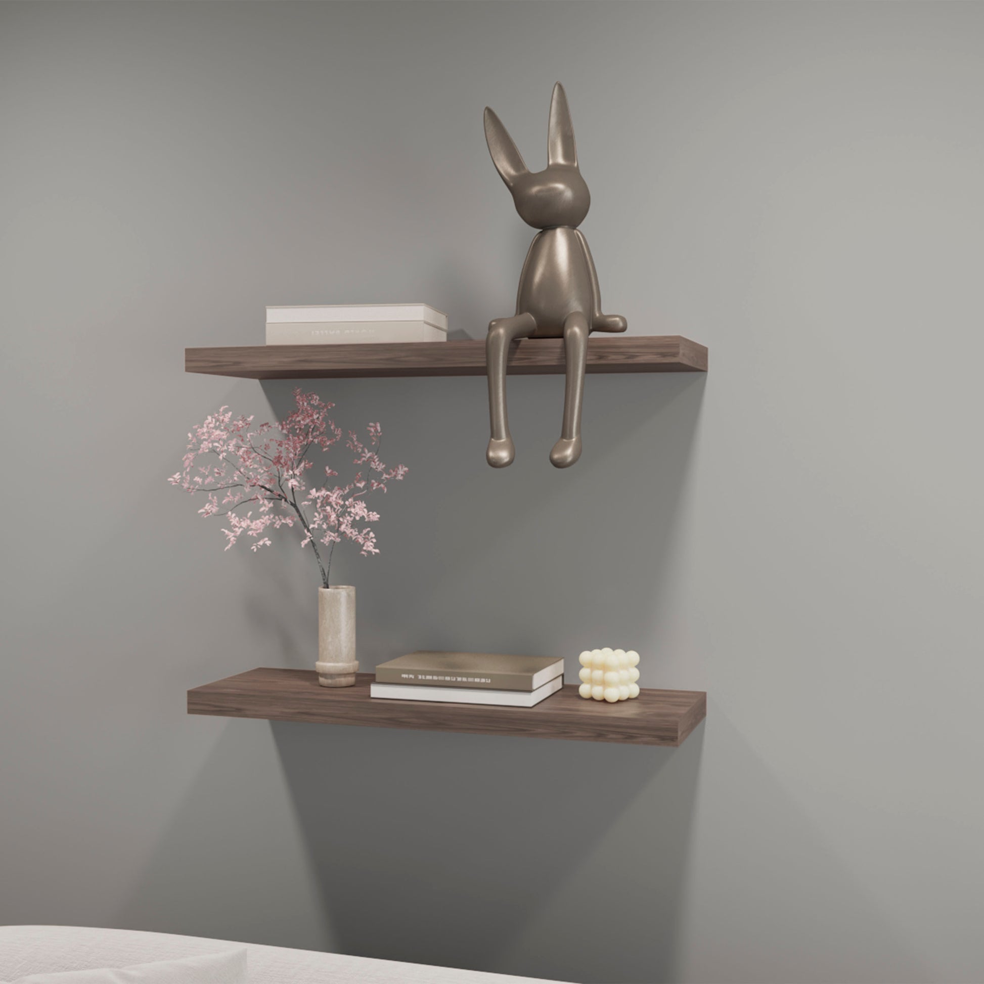 Silver metallic bunny sculpture with long ears perched on a wooden shelf
