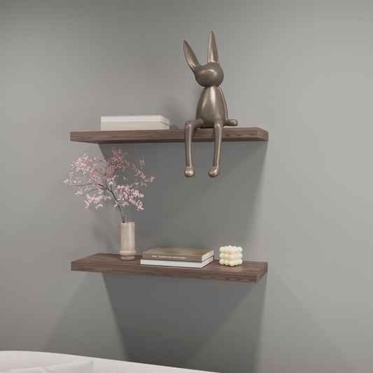 Silver metallic bunny sculpture with long ears perched on a wooden shelf