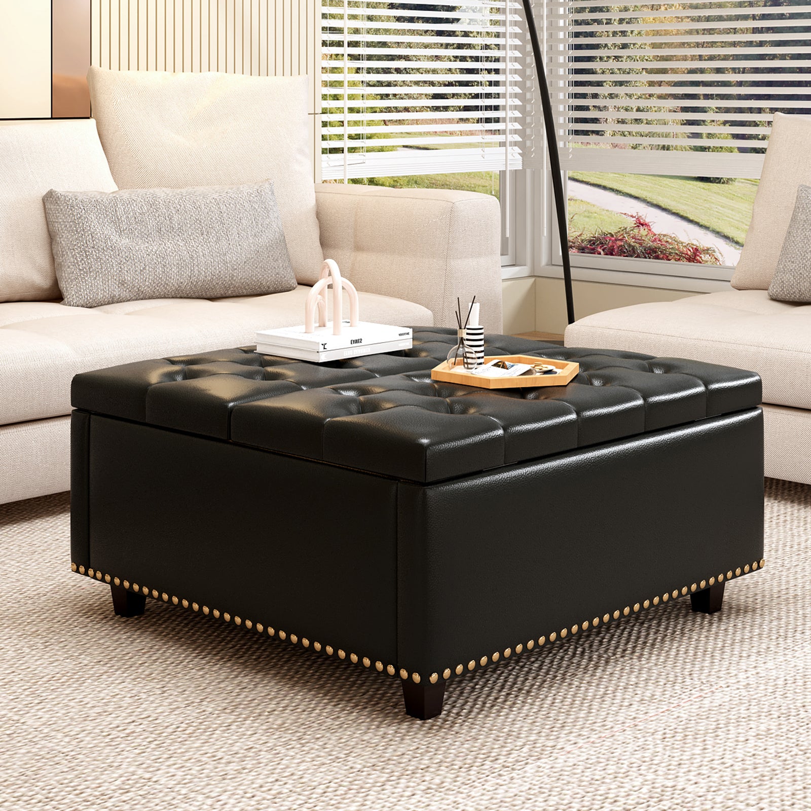 Tufted black faux leather storage ottoman with antique brass nailhead trim