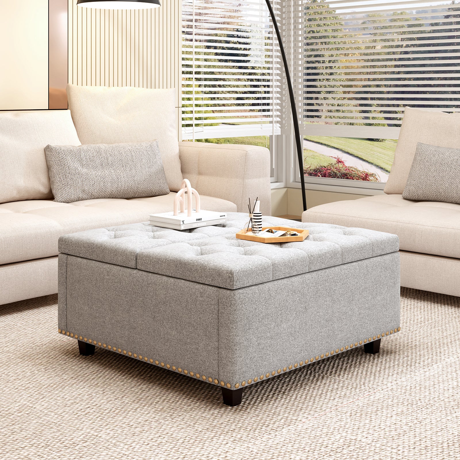 Gray fabric storage ottoman with button tufting and nailhead trim