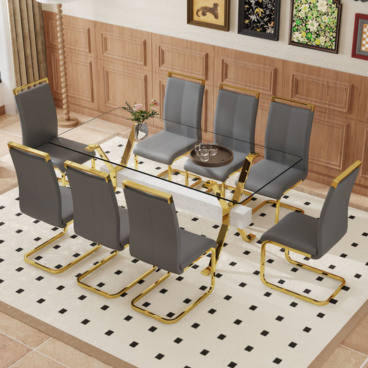 Modern glass dining table with gold accents and grey upholstered chairs