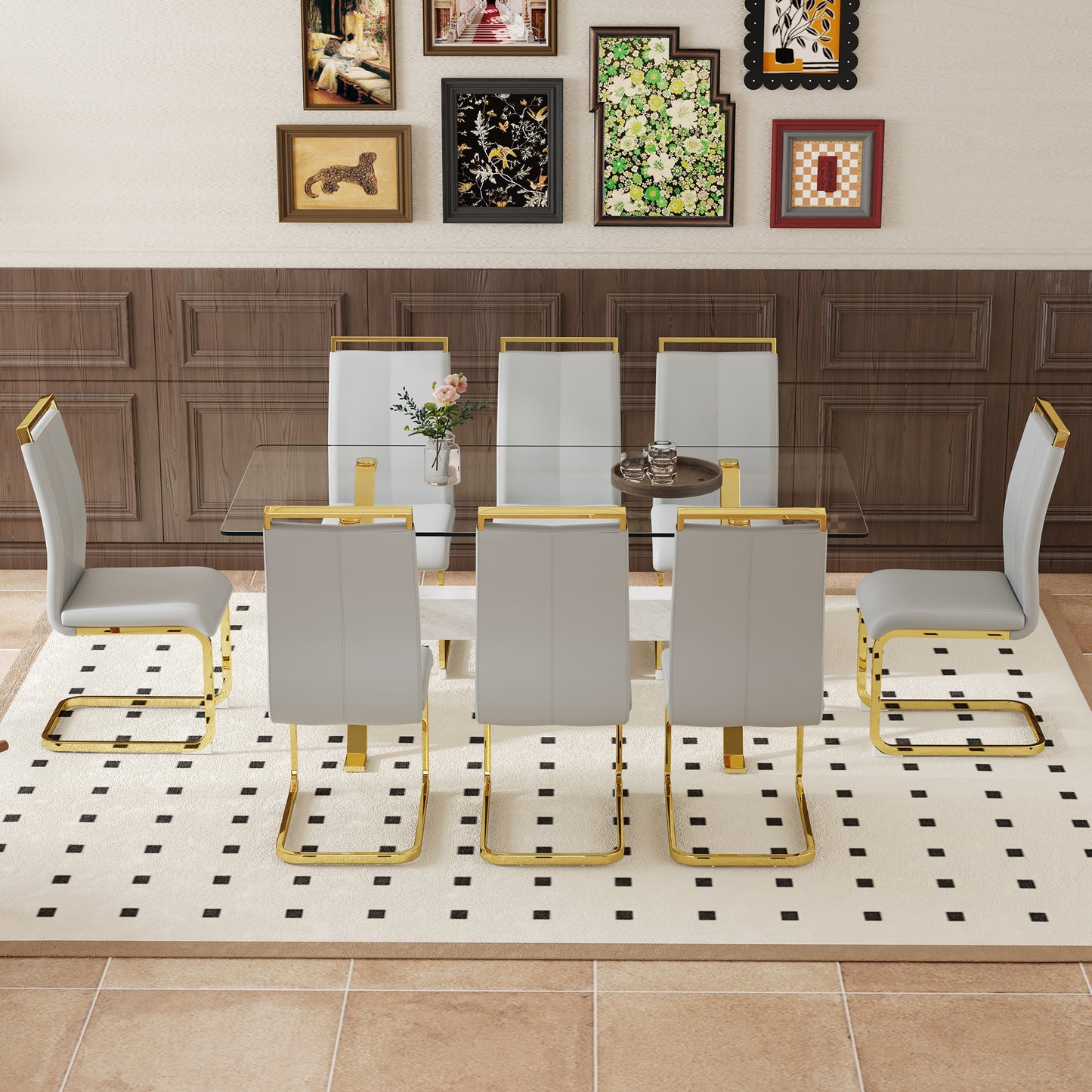 Six grey faux leather dining chairs with gold metal frames around a glasstop table