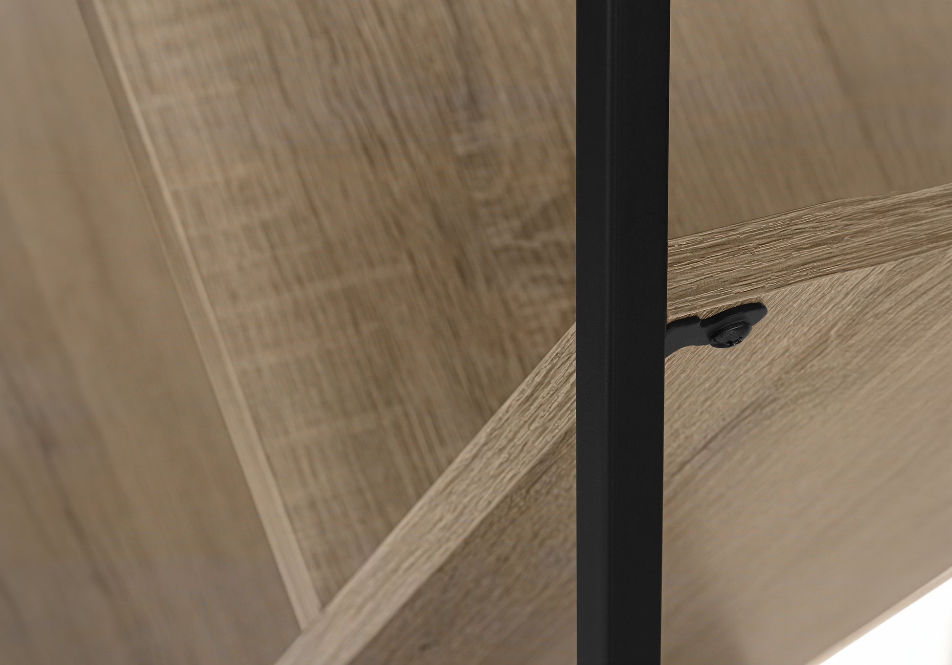 Closeup of a light oak shelf with black metal support bracket