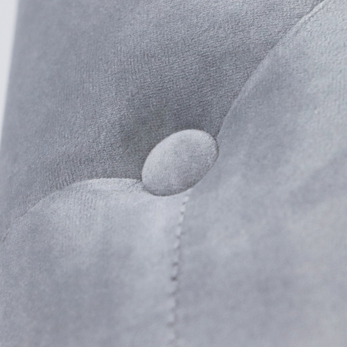 Close up of tufted grey velvet fabric with button detail