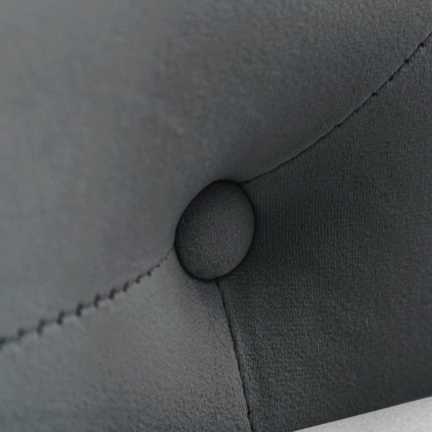 Closeup of dark grey velvet tufted furniture detail