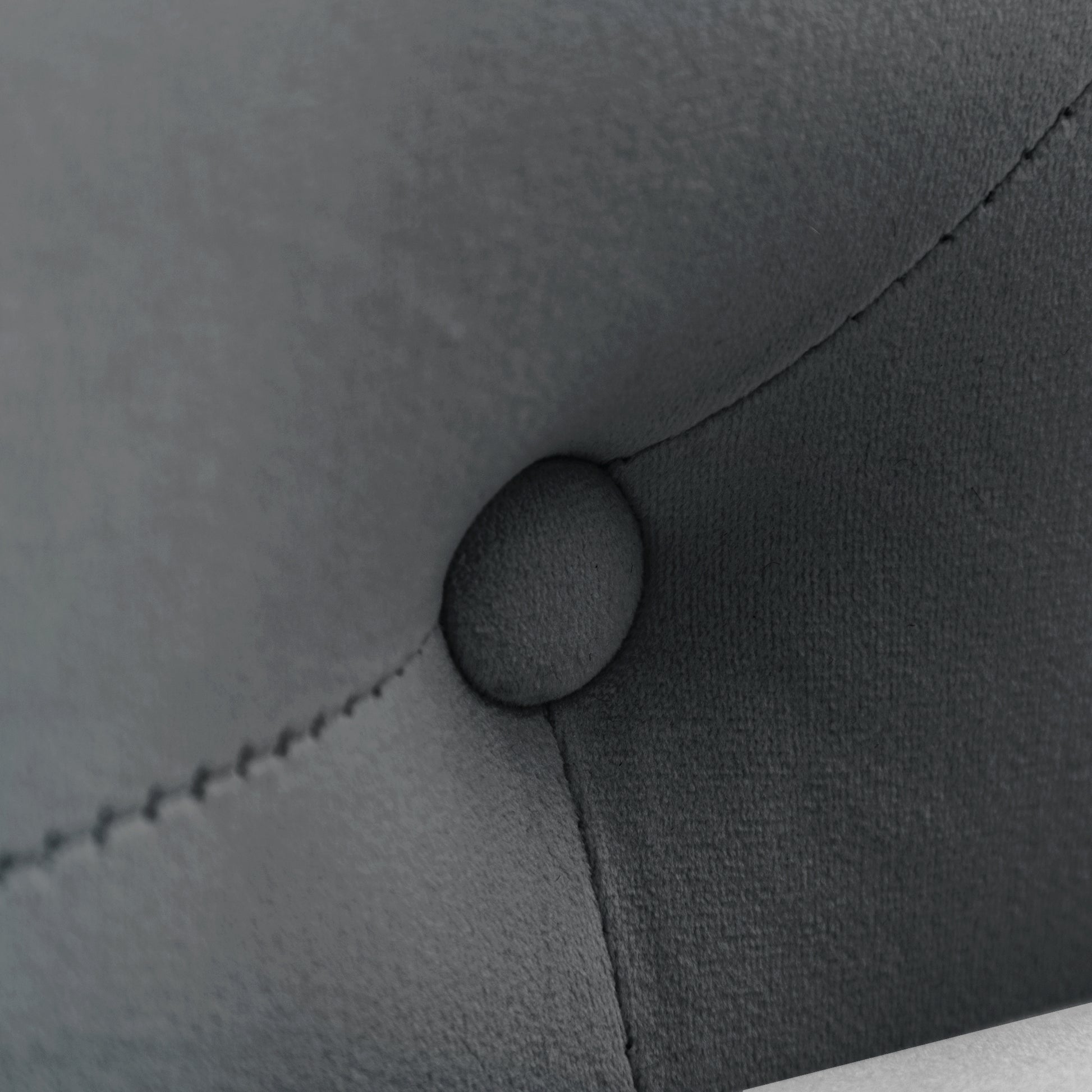 Closeup of dark grey velvet tufted furniture detail