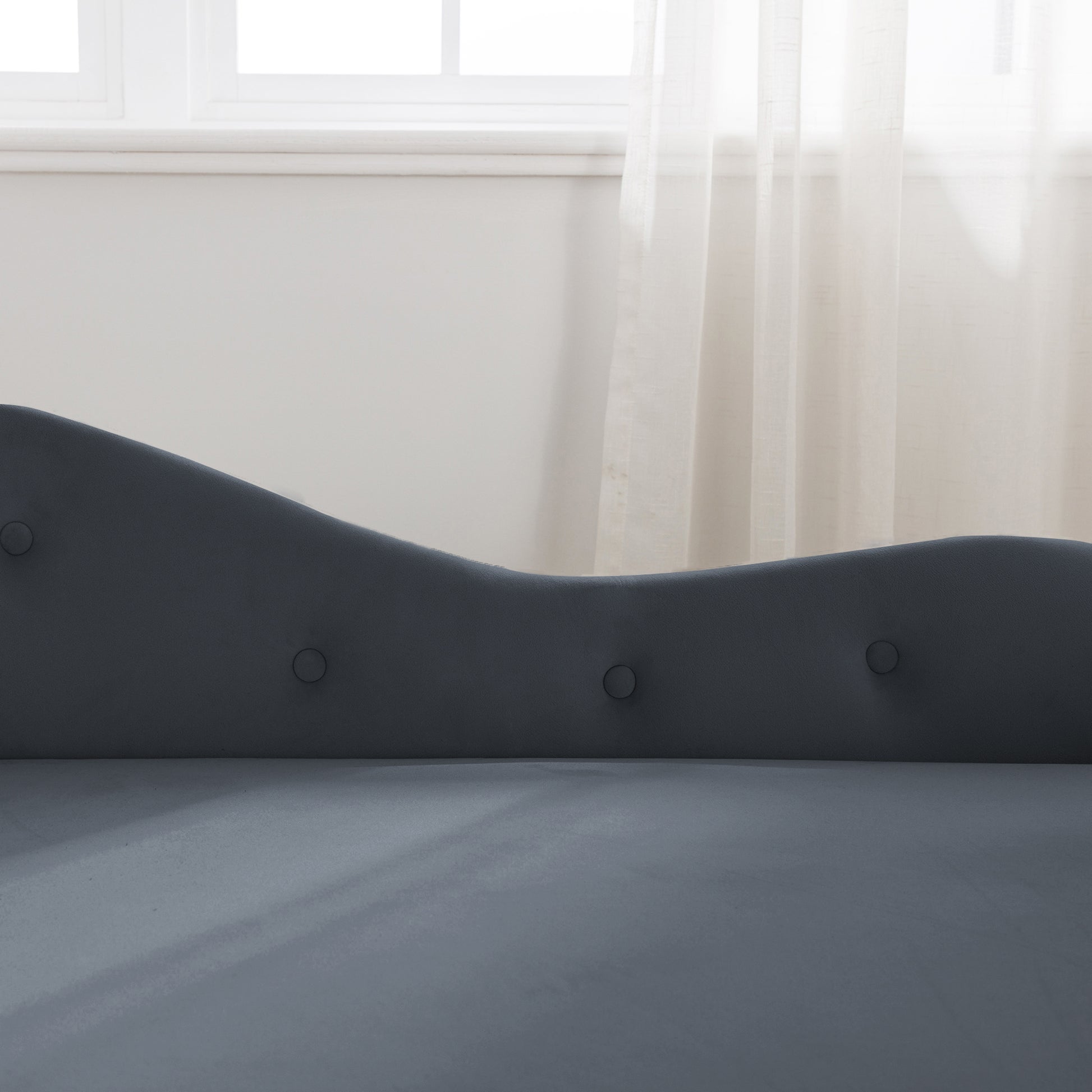 Dark gray velvet chaise lounge with button tufting