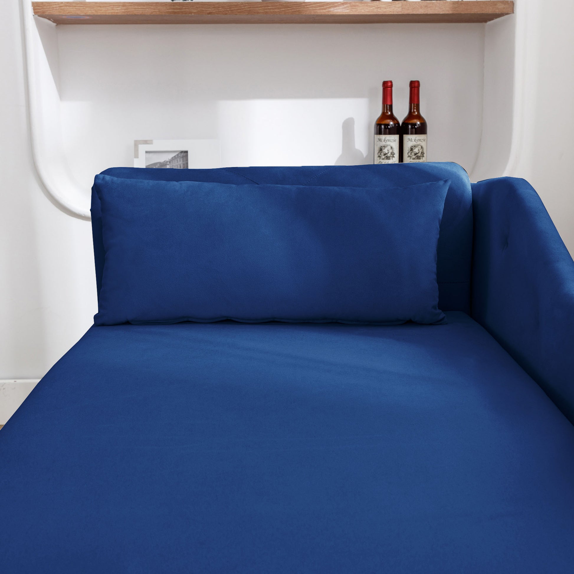 Deep blue velvet chaise lounge with matching lumbar pillow for stylish relaxation