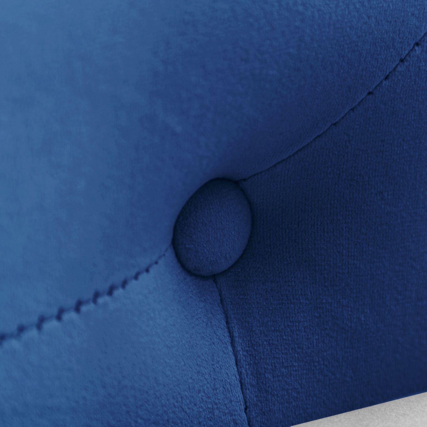 Closeup of tufted sapphire blue velvet fabric with button detail