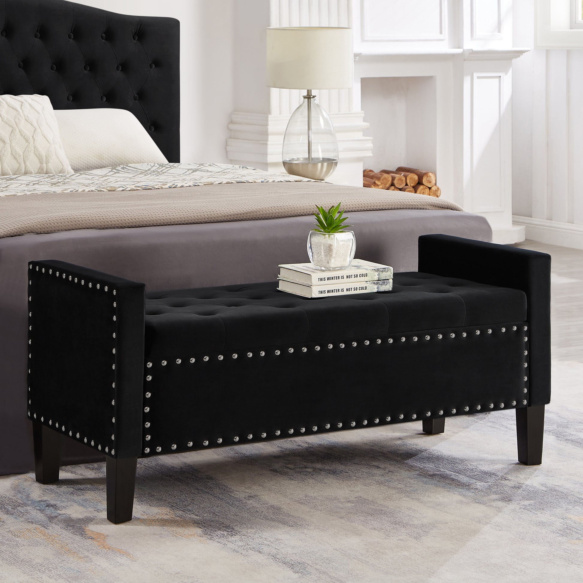 Black velvet storage bench with silver nailhead trim and button tufting