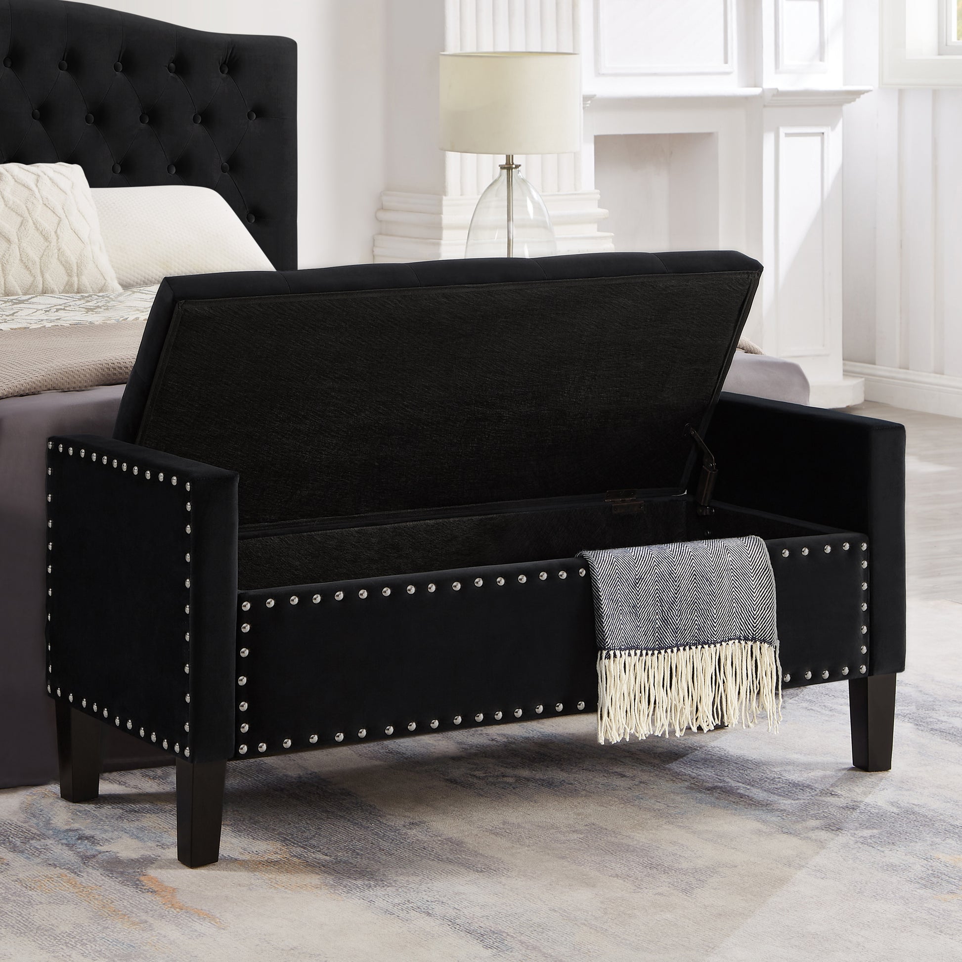 Black velvet storage bench with silver nailhead trim