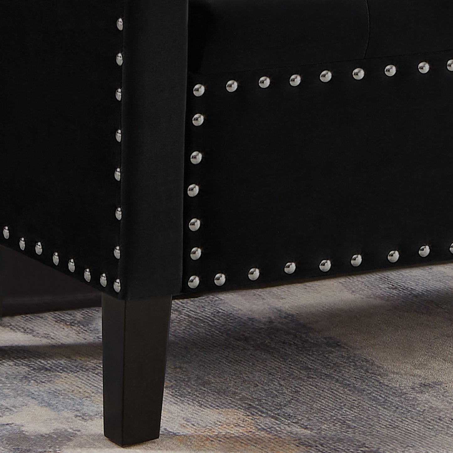 Black velvet armchair with silver nailhead trim and dark wooden legs