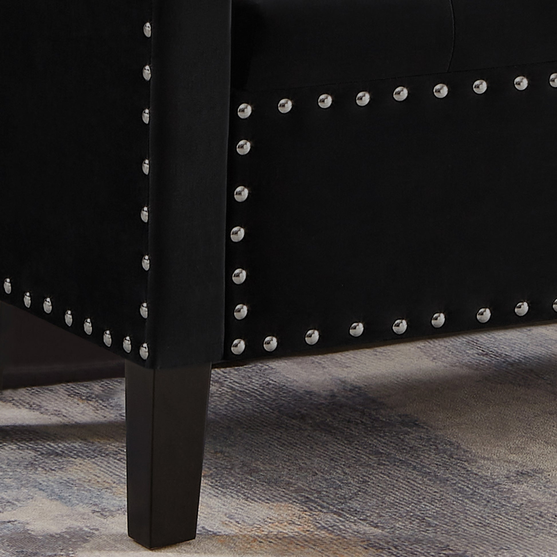 Black velvet armchair with silver nailhead trim and dark wooden legs