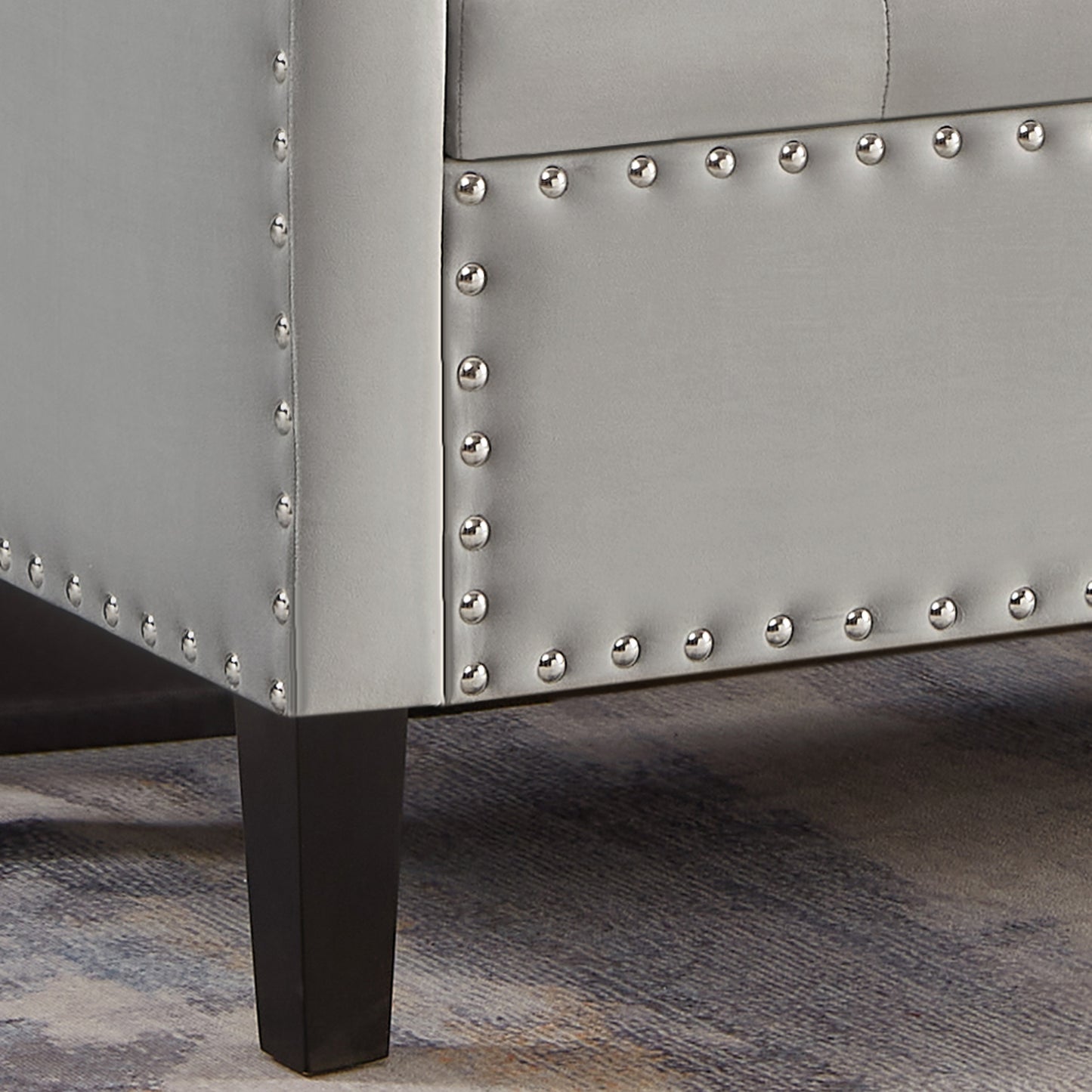 Silver faux leather ottoman with polished nailhead trim