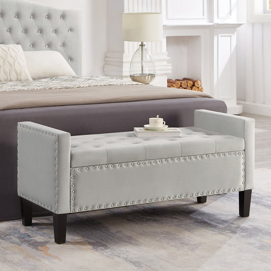 Light gray tufted storage bench with silver nailhead trim