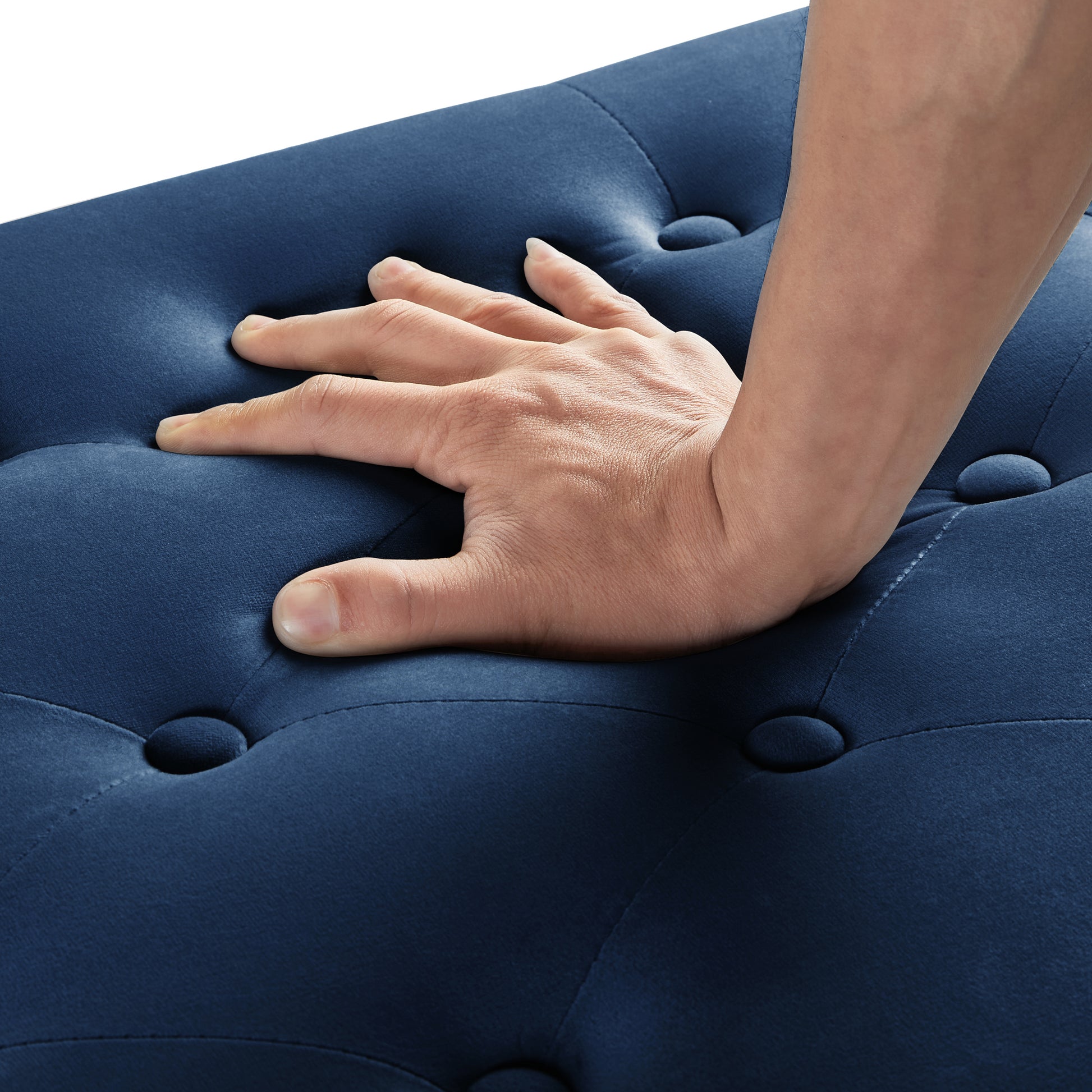 Hand pressing plush navy blue velvet ottoman with button tufting