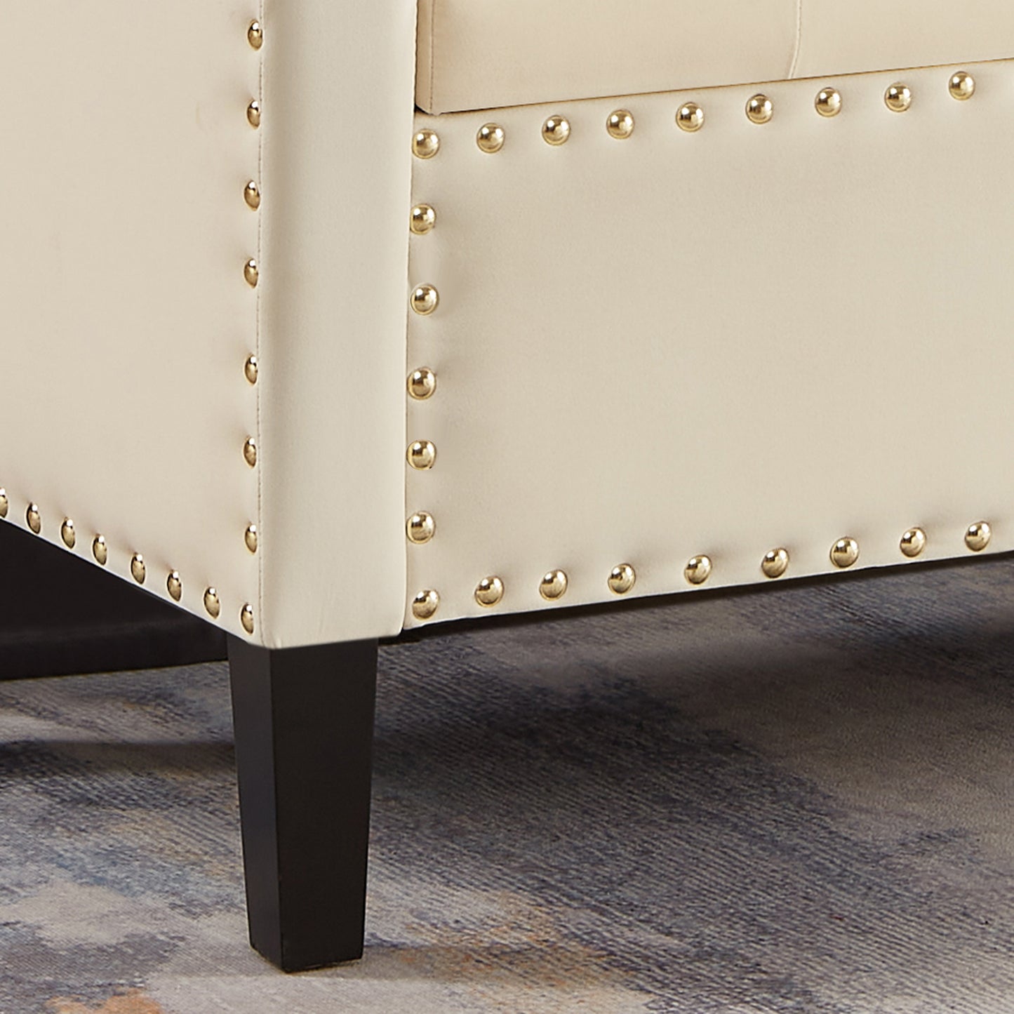 Cream upholstered bench with gold nailhead trim and dark wood legs