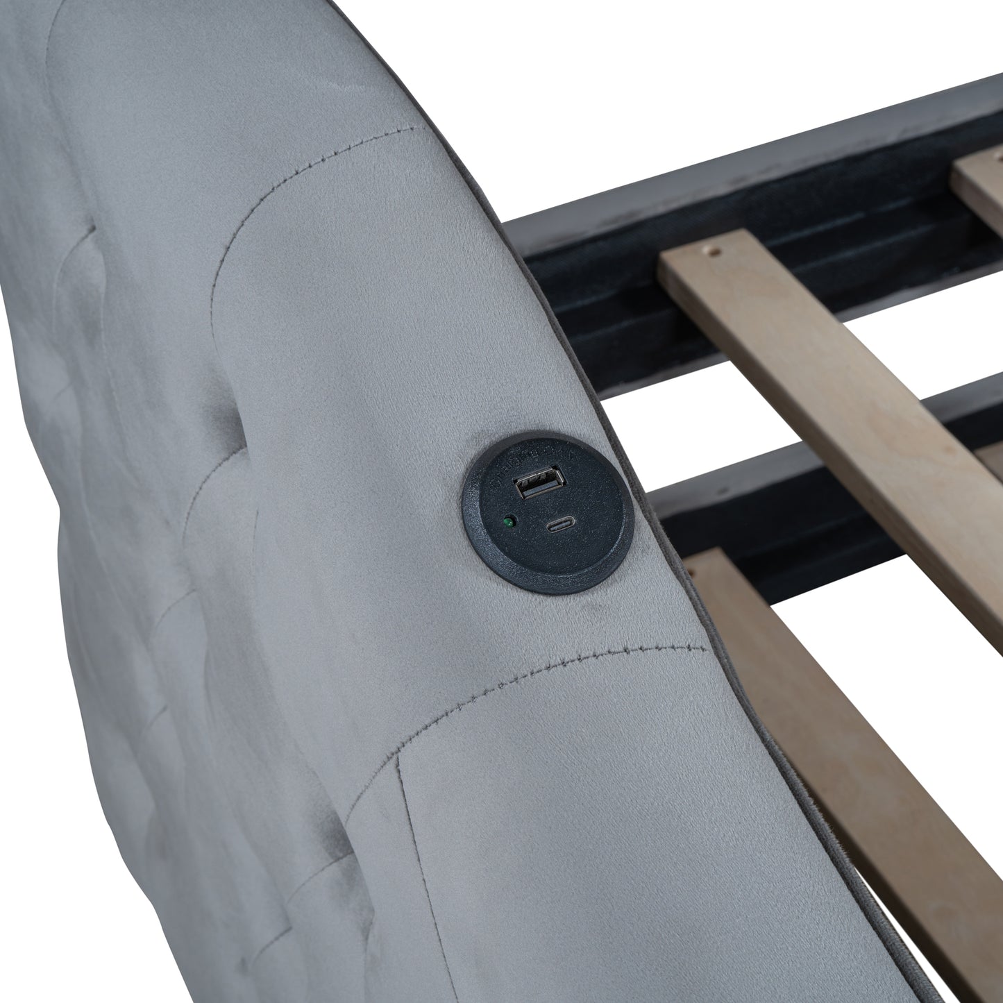 Closeup of a tufted grey upholstered bed frame with integrated USB charging ports