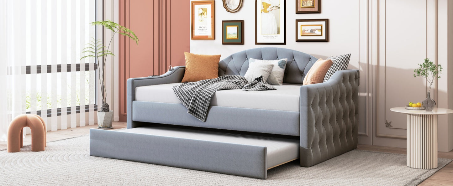 Light blue velvet daybed with tufted arms and a pullout trundle