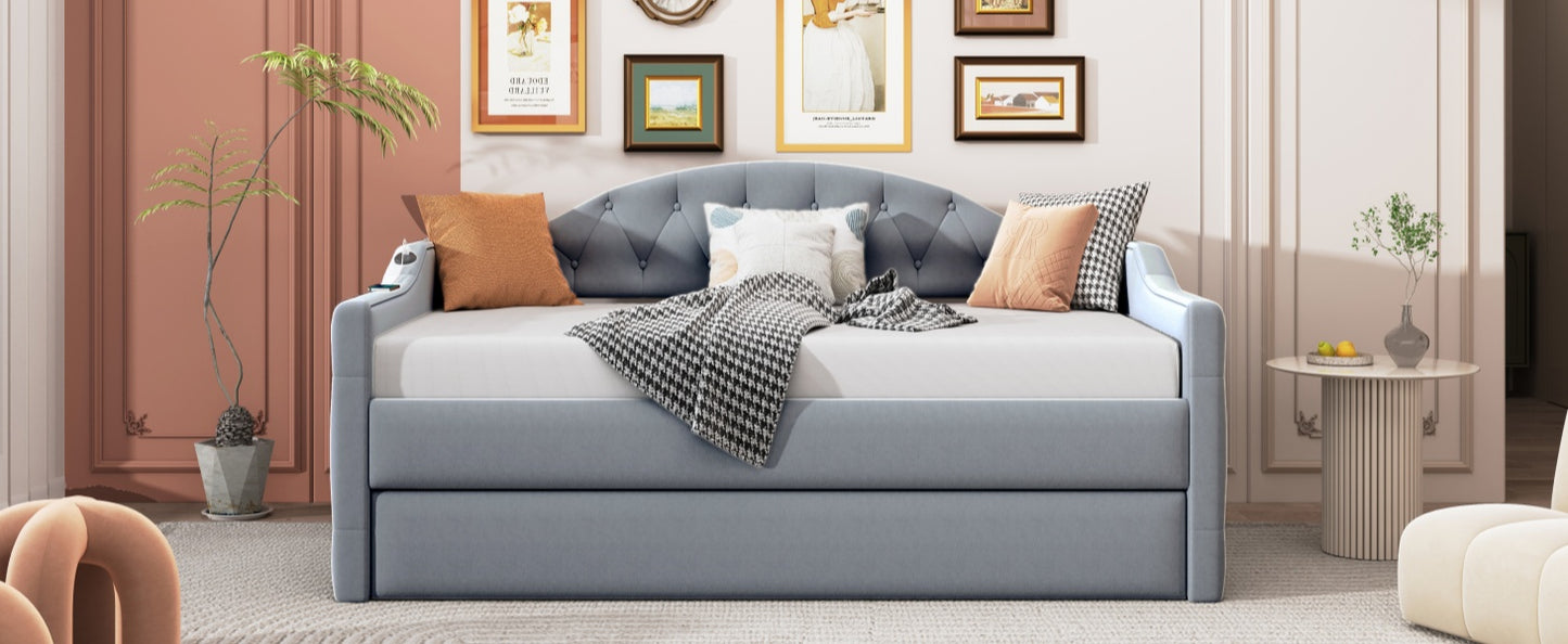 Light blue velvet daybed with tufted back and pullout trundle featuring decorative pillows and a throw blanket