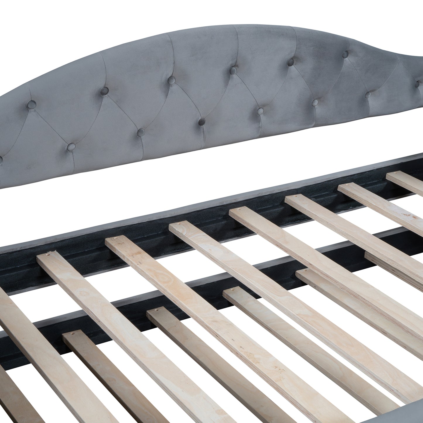 Closeup of grey velvet tufted headboard and wooden slats of a bed frame