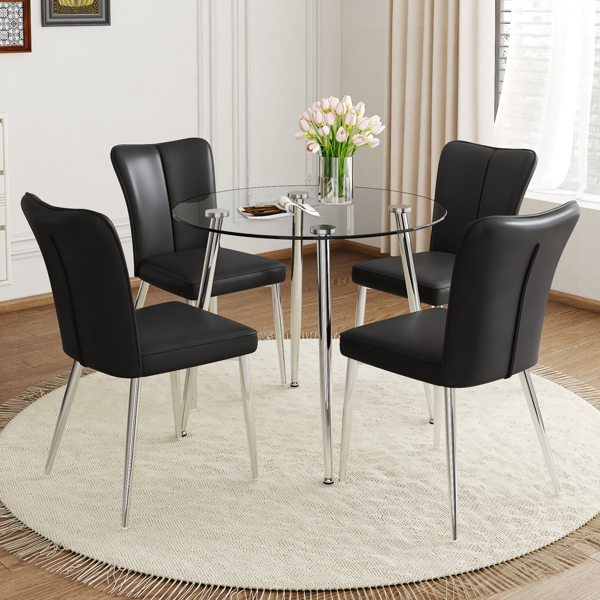 Round glass dining table with four black faux leather chairs
