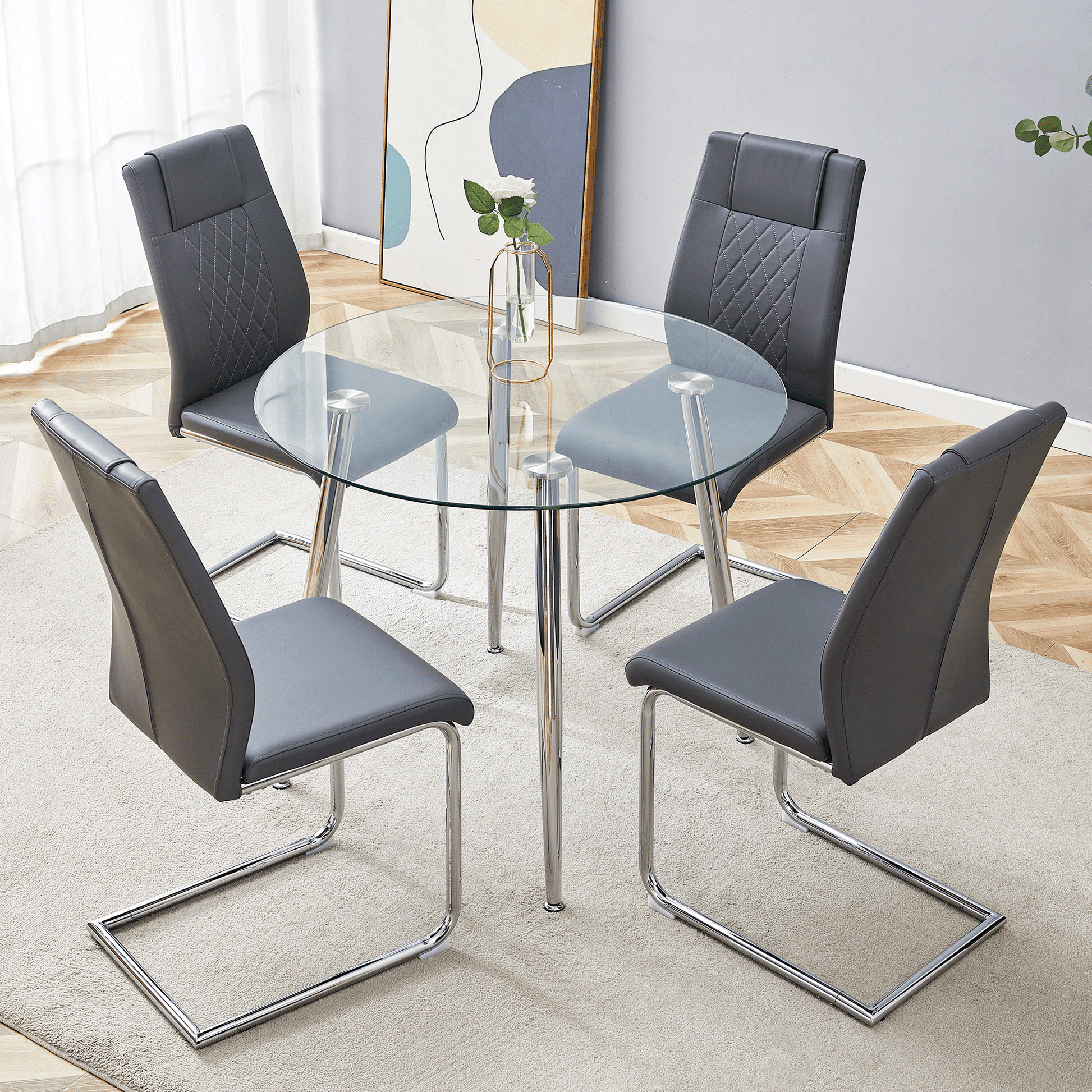 Round glass dining table with four grey faux leather chairs