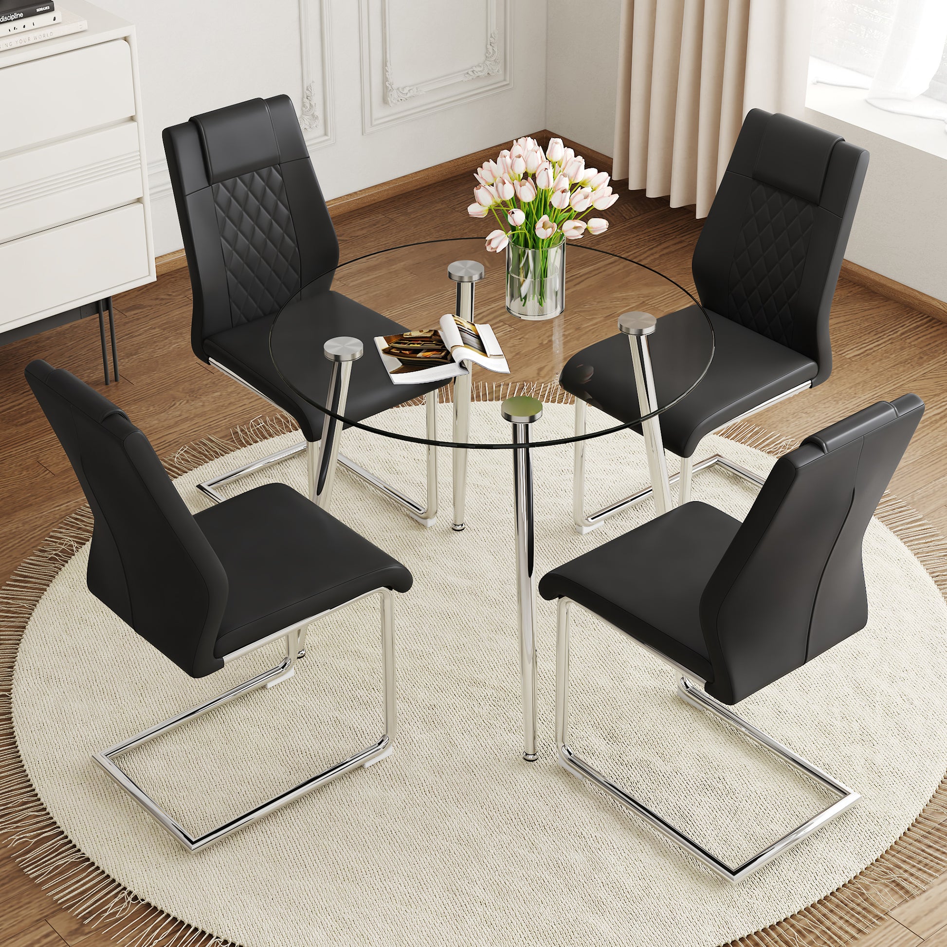 Black faux leather dining chairs with diamond stitching around a clear glass table