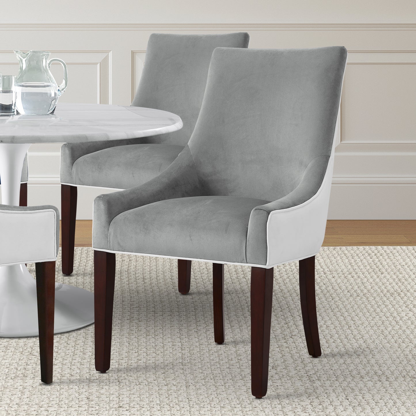 Grey velvet dining chair with white trim and dark wood legs