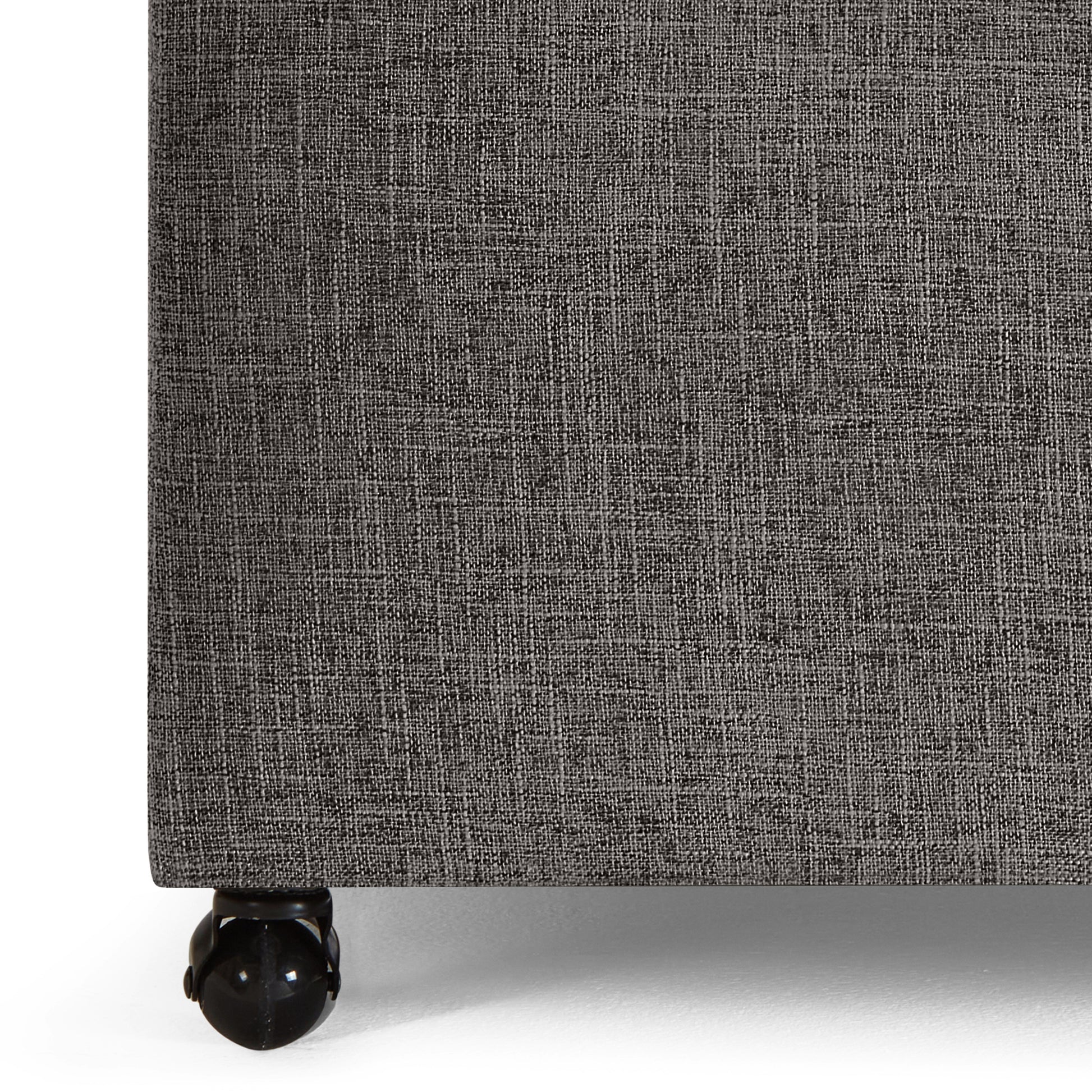 Closeup of grey textured fabric on a rolling ottoman base