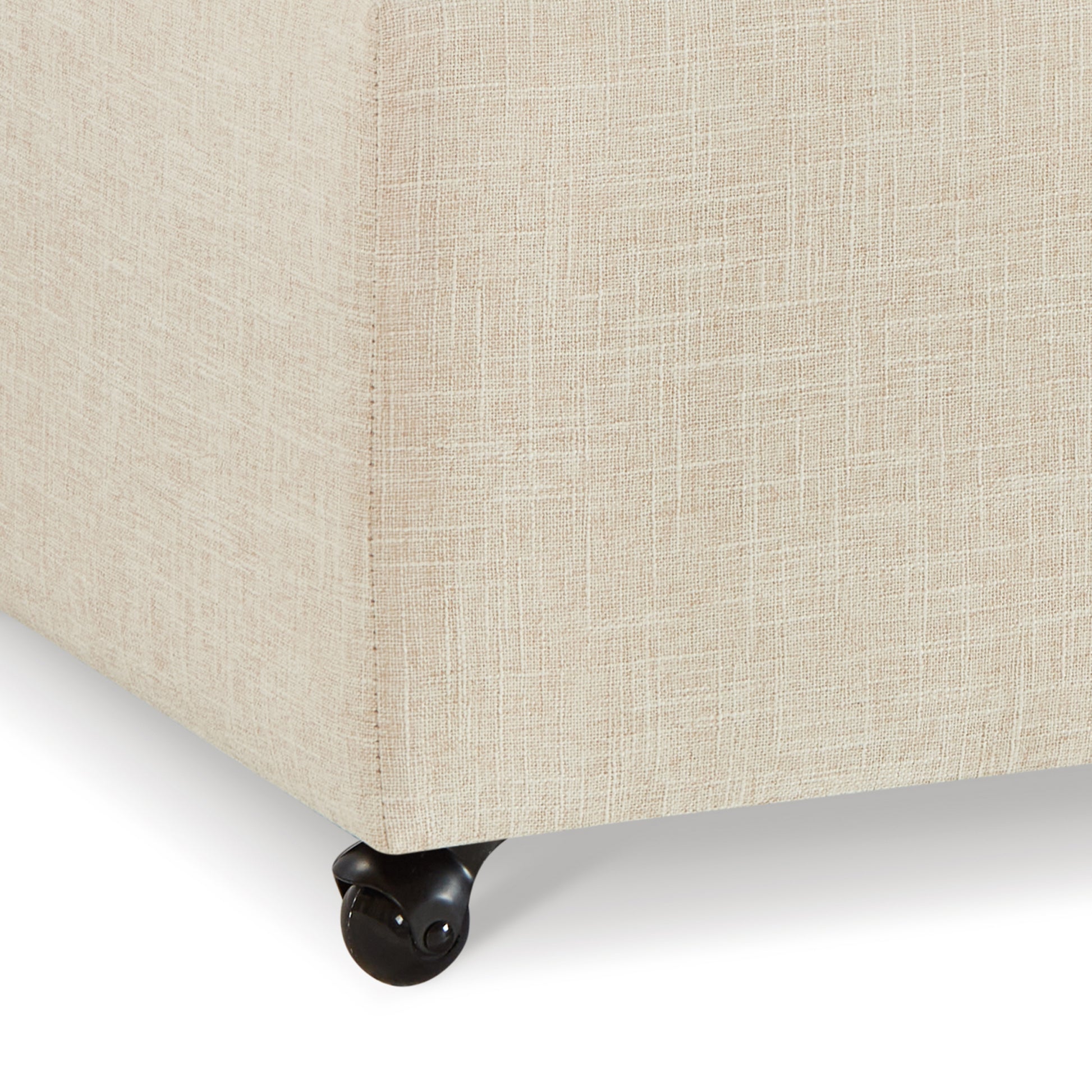 Cream fabric ottoman corner with black caster wheel
