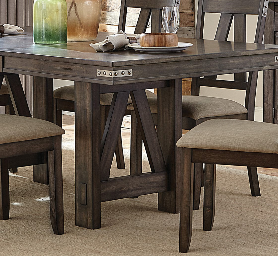 Rustic dark wood dining table with riveted accents and upholstered chairs