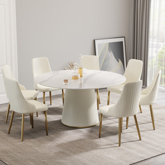 Cream upholstered dining chairs with gold legs surrounding a round marble tabletop