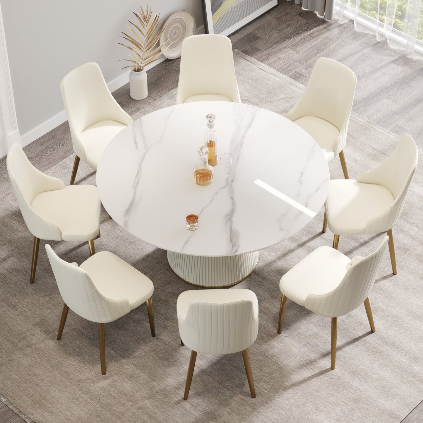 Cream velvet dining chairs with gold legs arranged around a white marble pedestal table