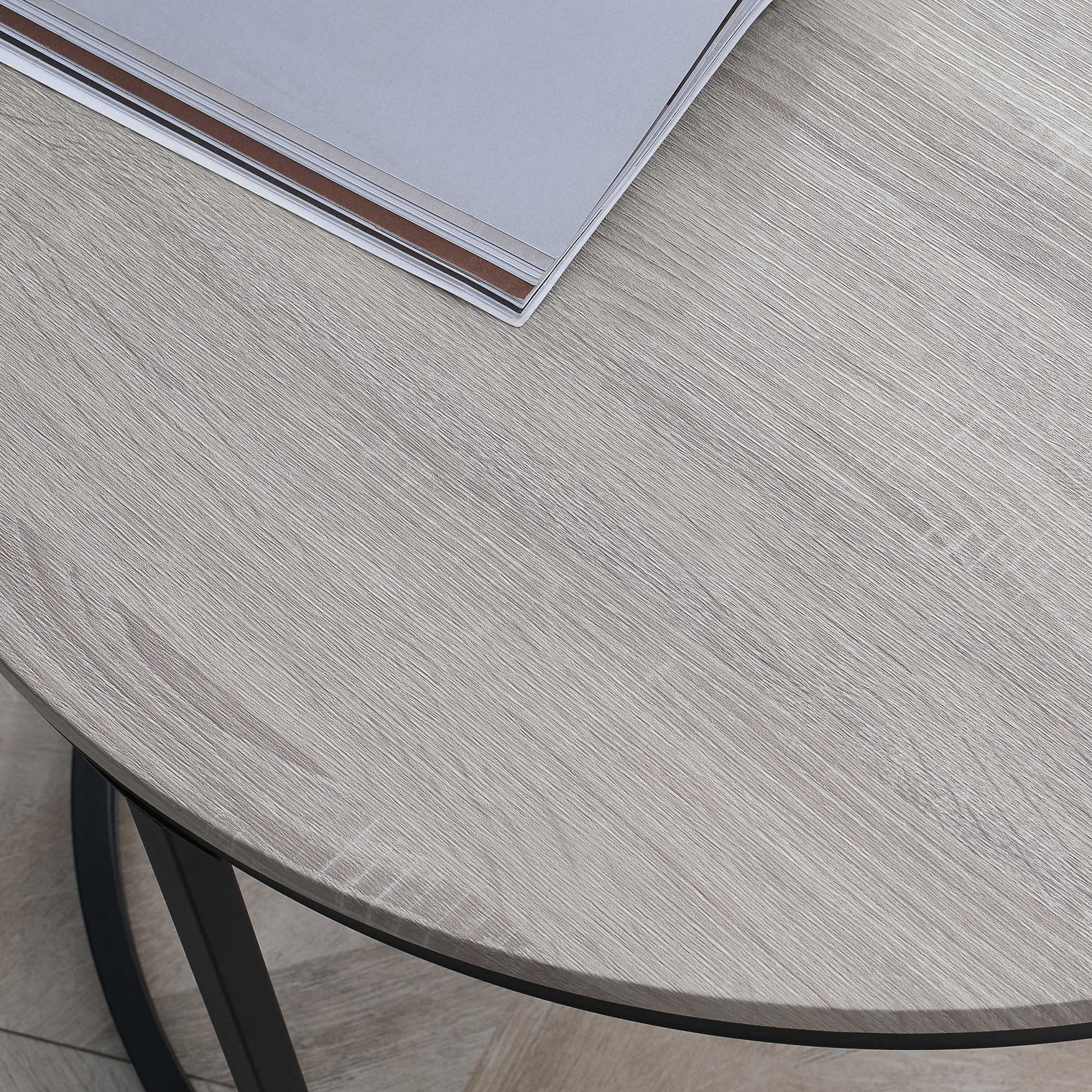 Closeup of light oak veneer tabletop with black metal legs