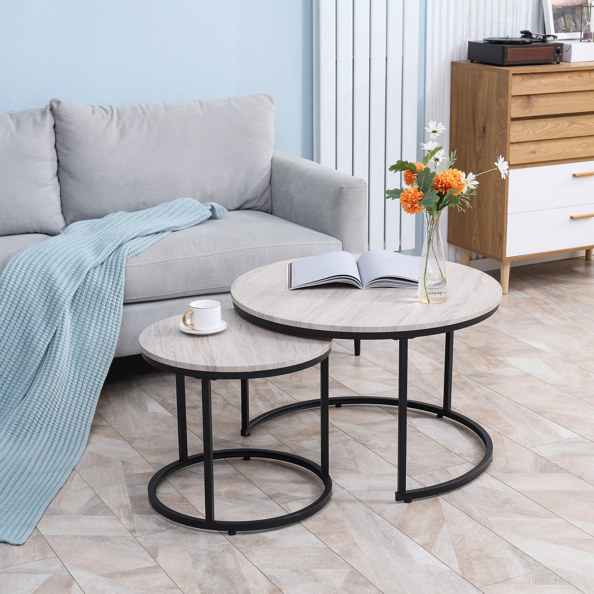 Round nesting coffee tables with light wood finish and black metal legs