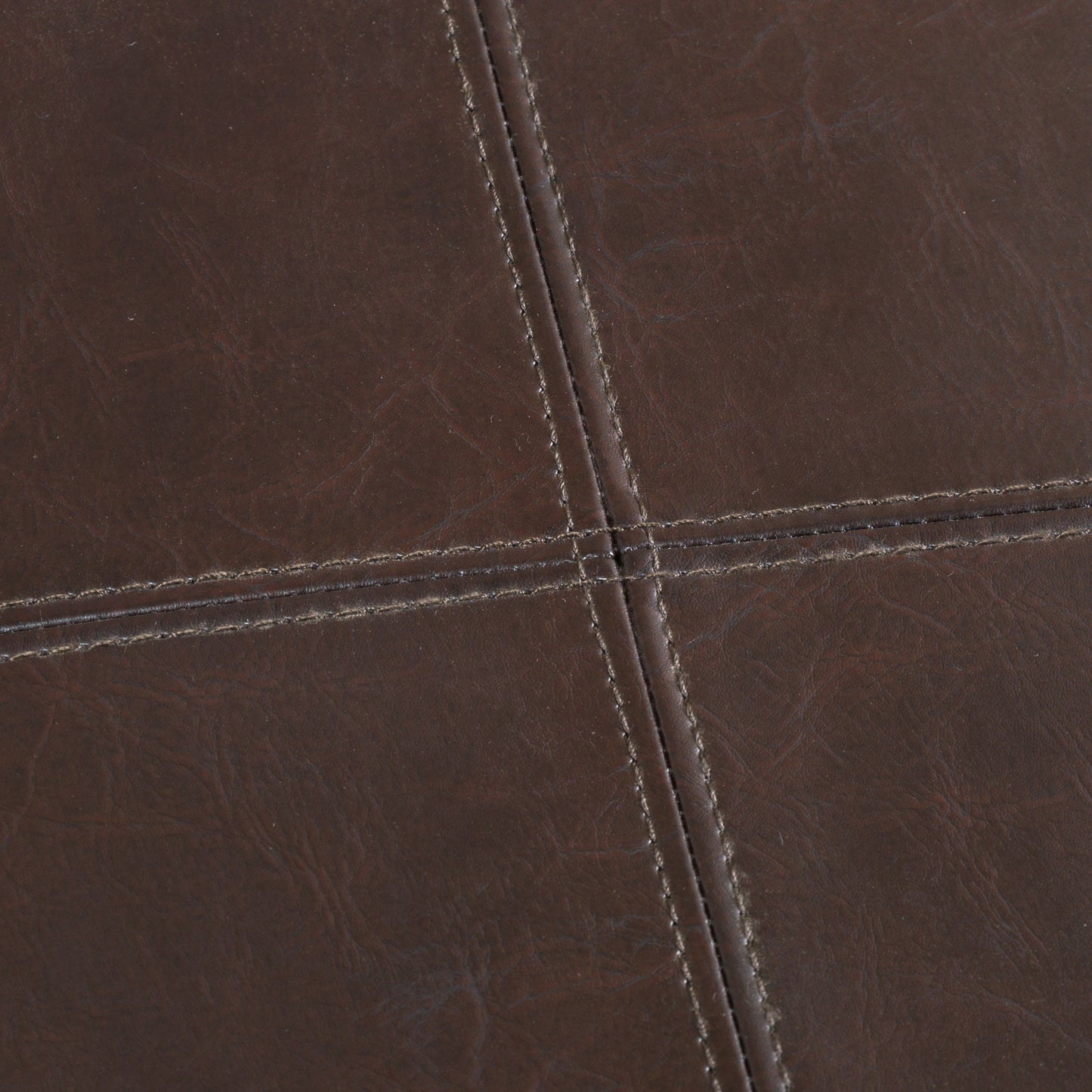 Closeup of dark brown stitched faux leather texture