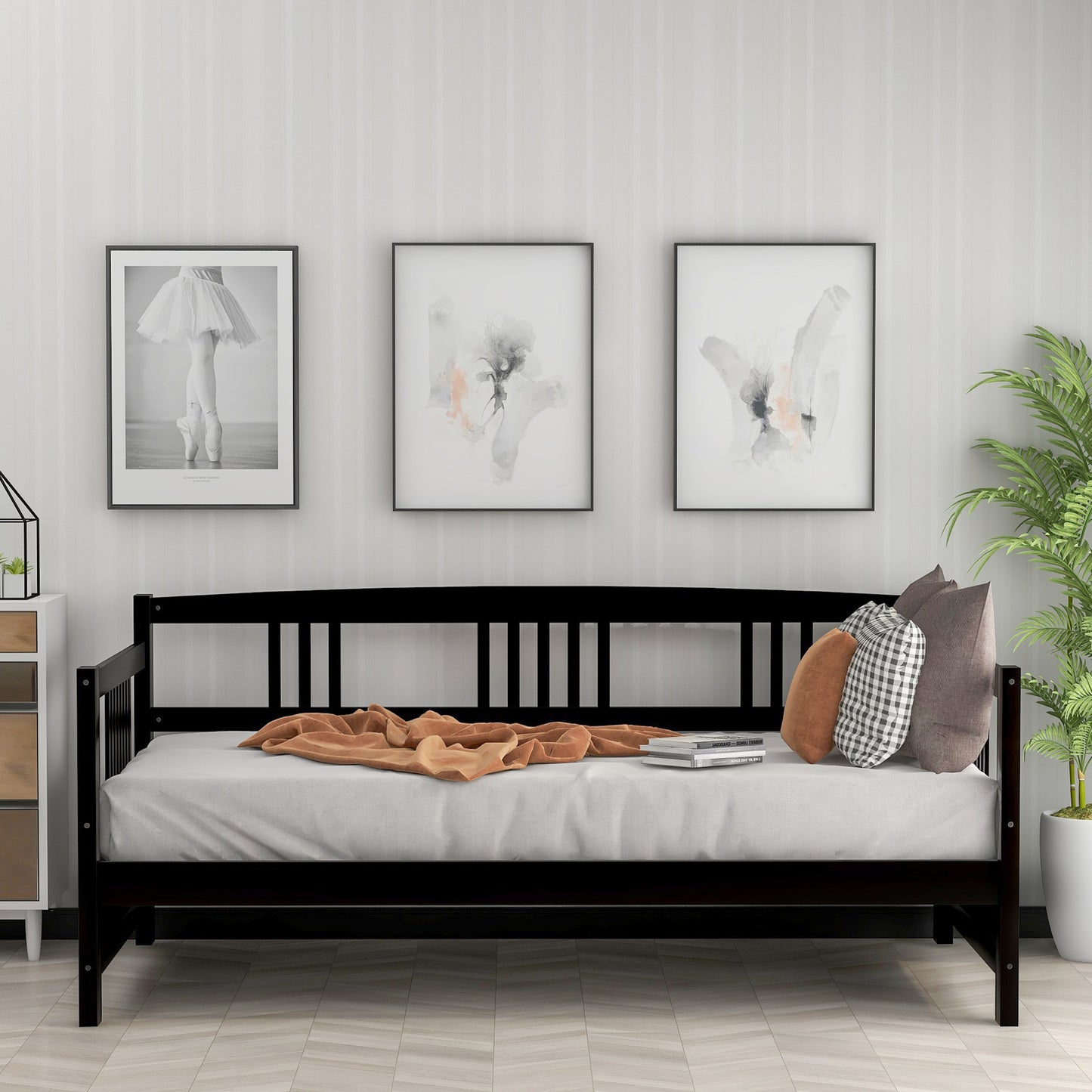 Black wooden daybed with white mattress and orange throw