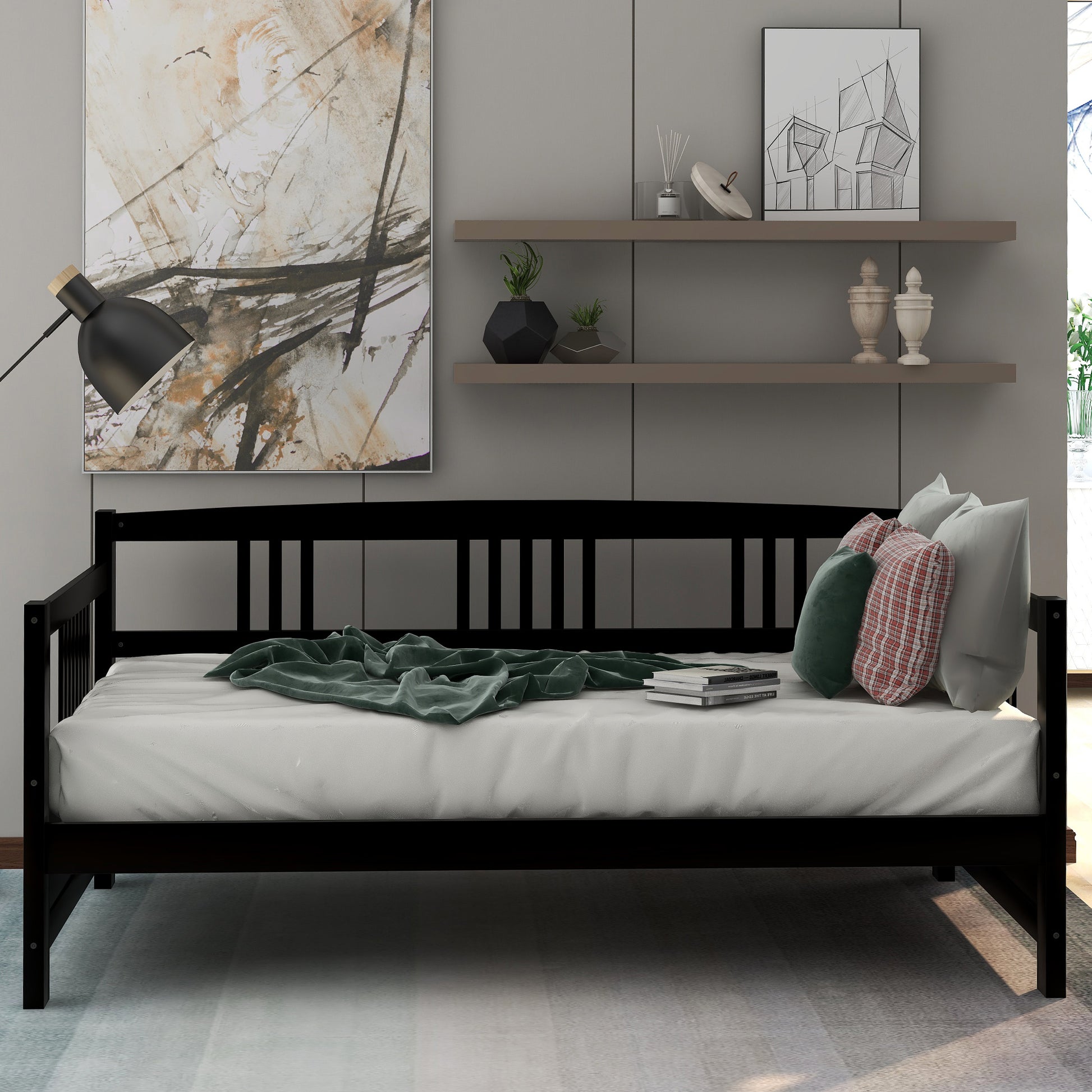 Black wooden daybed with white mattress and green throw