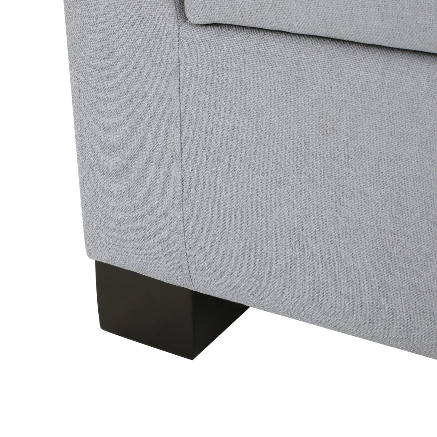 Closeup of a grey fabric sofa corner with a dark wood leg