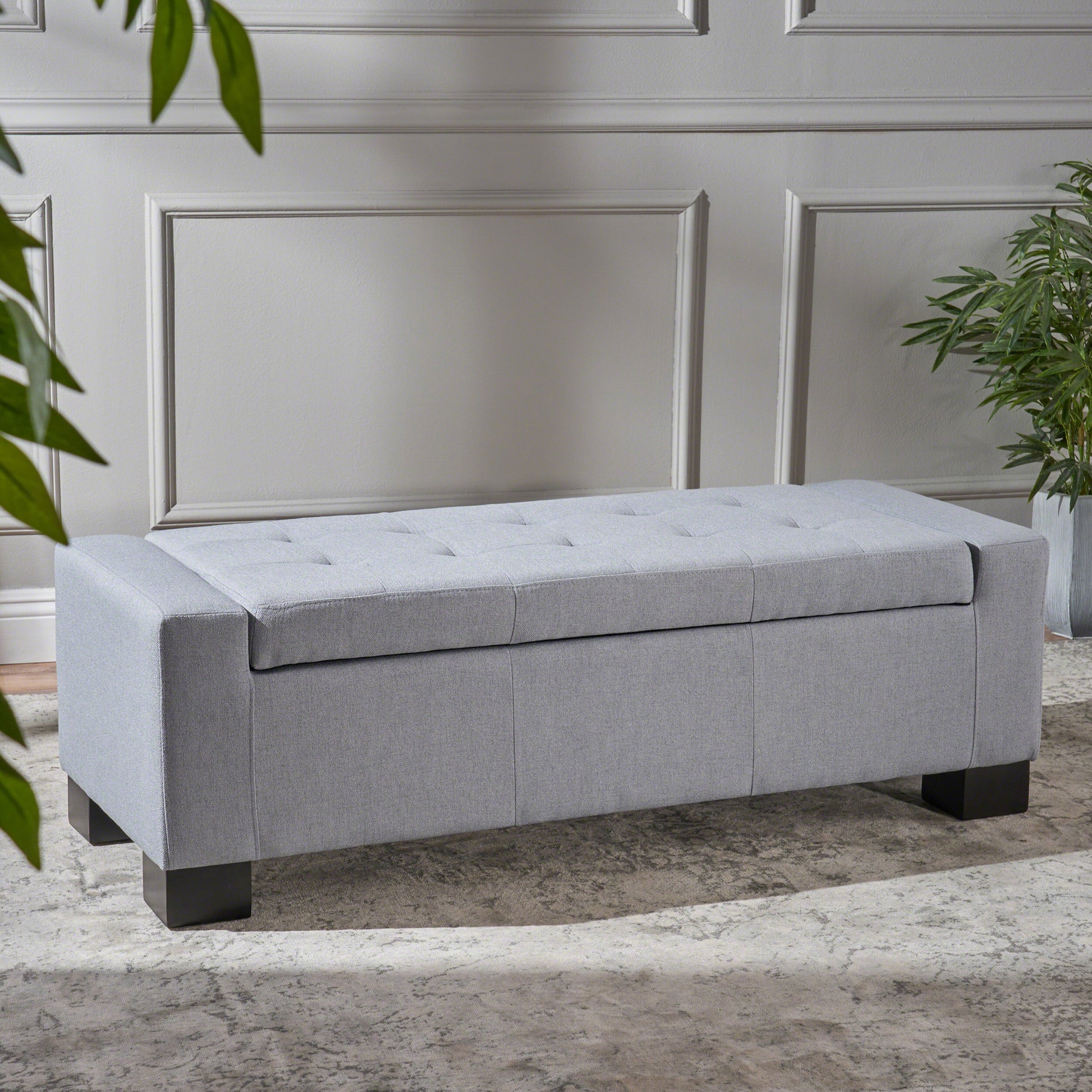 Light gray tufted storage ottoman with dark wood legs