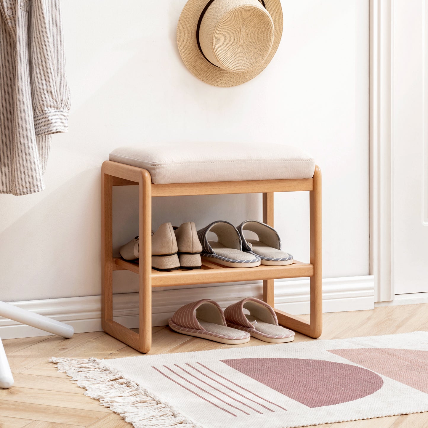 Wooden shoe rack with cushioned seat and beige slippers on bottom shelf