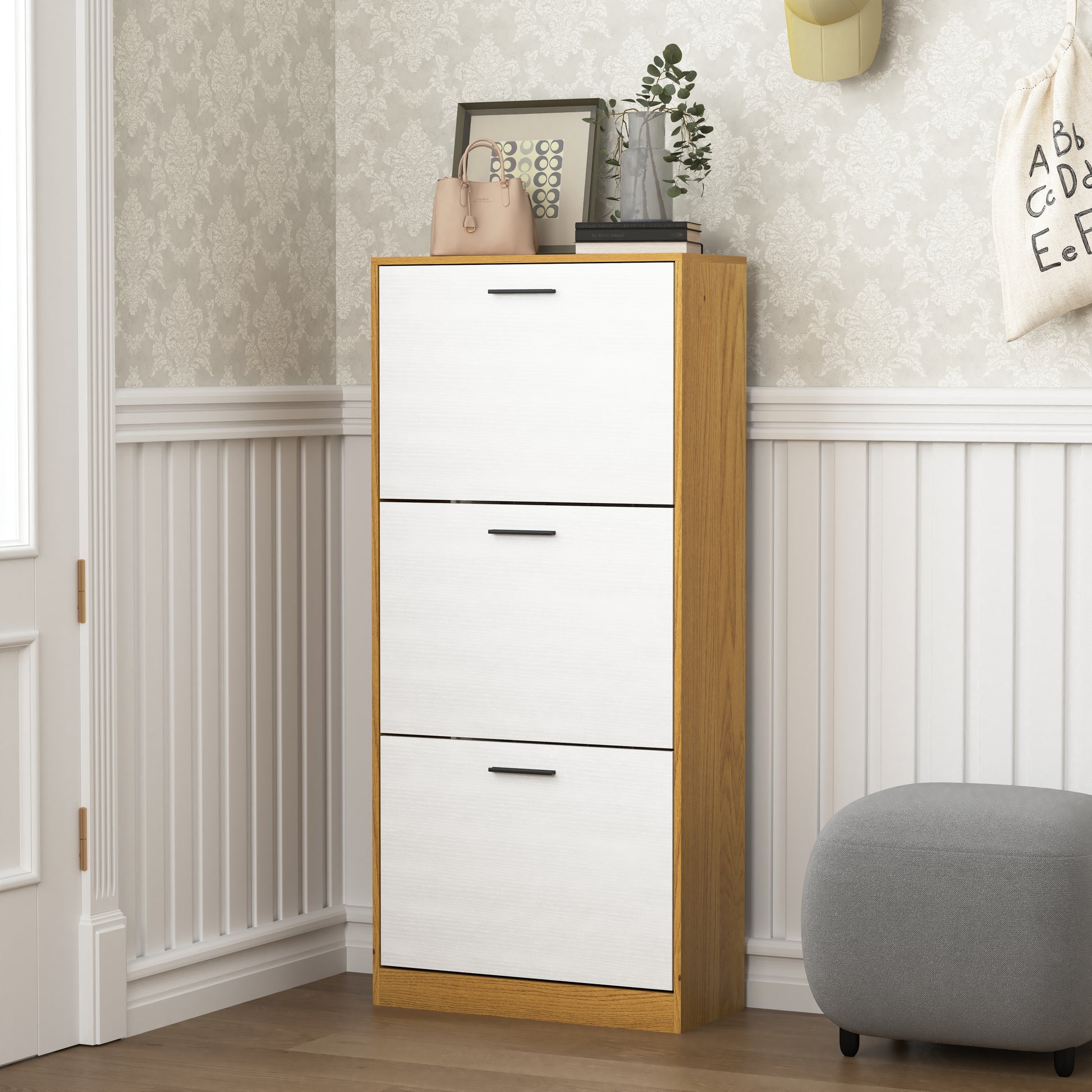 Narrow entryway shoe cabinet with three white pulldown doors and oak wood frame