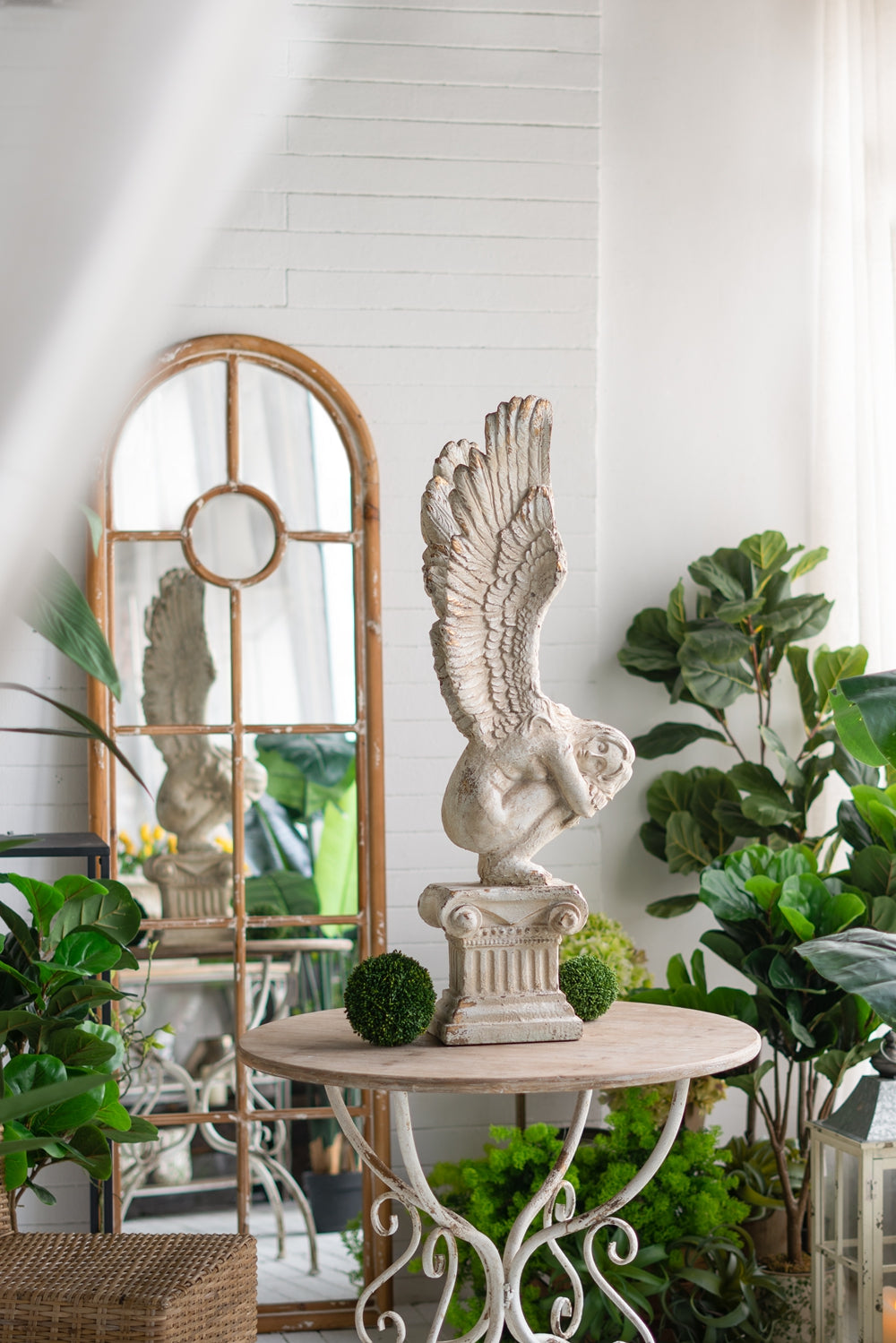 Faux distressed angel statue accent piece on pedestal