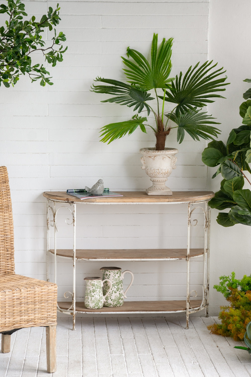 Rustic white console table with distressed wood shelves and ornate metalwork