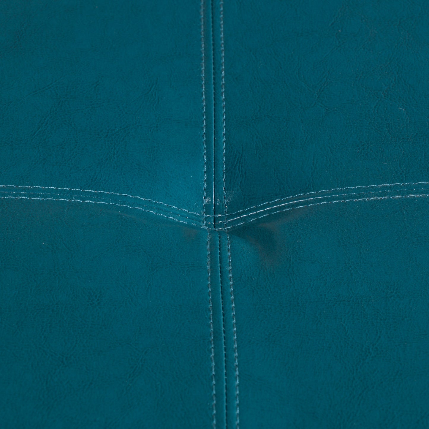 Teal faux leather sofa upholstery with contrasting white stitching