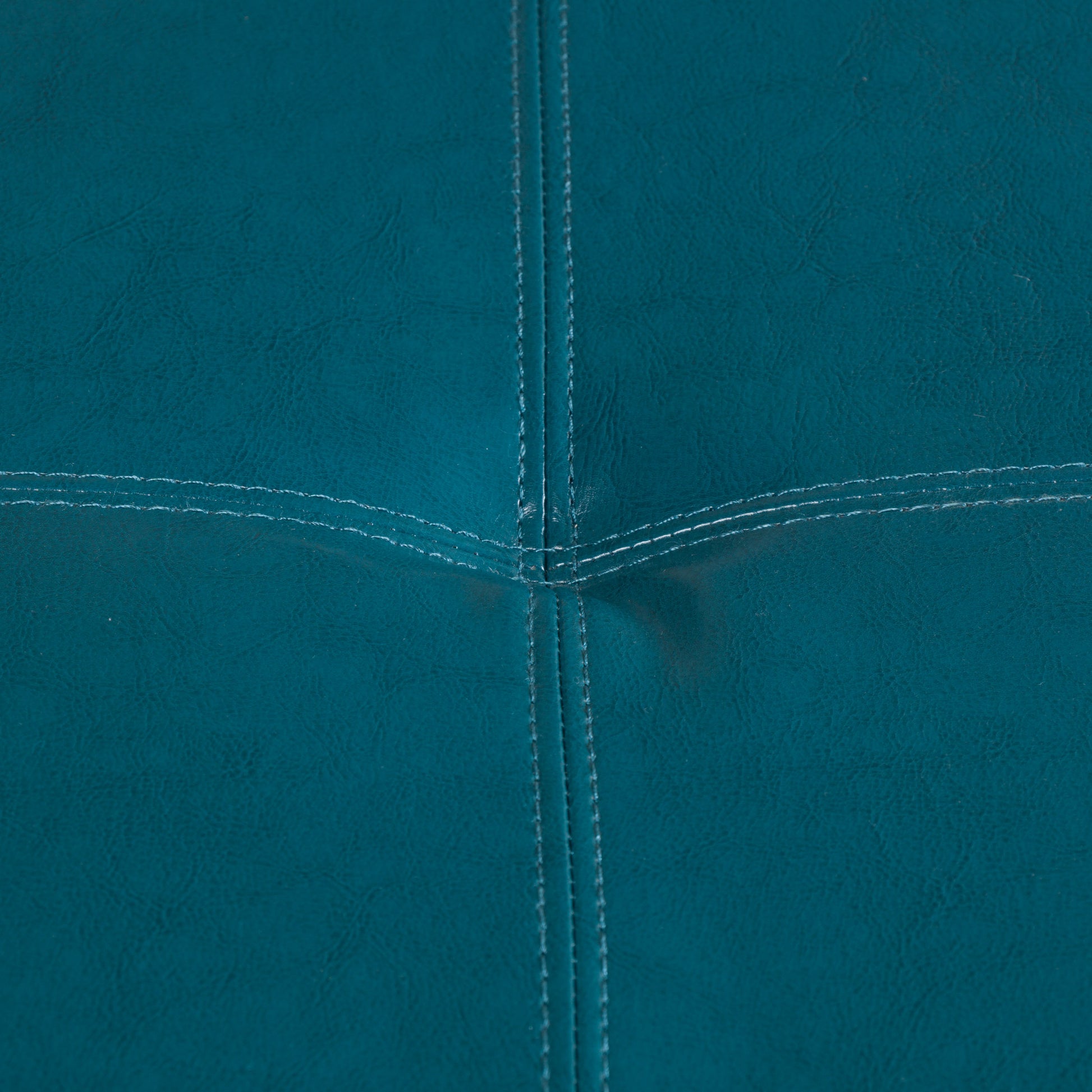 Teal faux leather sofa upholstery with contrasting white stitching