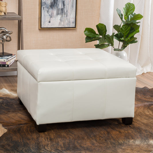 White faux leather storage ottoman with tufted lid and dark wood legs
