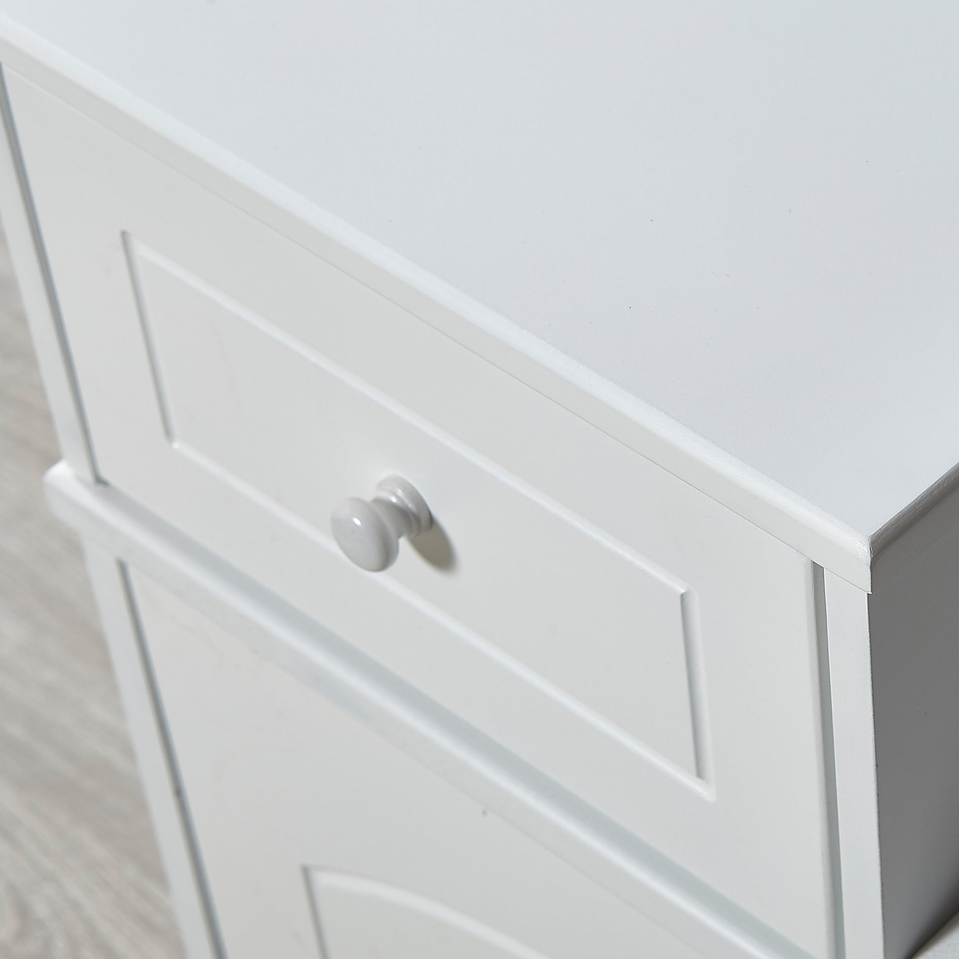 White wooden bedside table with detailed drawer fronts and a simple round knob